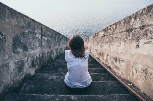 A woman sitting in front of the ocean wondering if there's such thing as people without feelings.