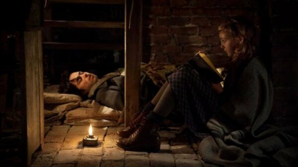 A girl reading to a man.