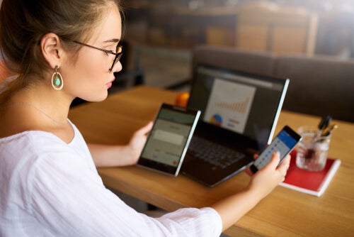 A woman playing with her electronic devices.