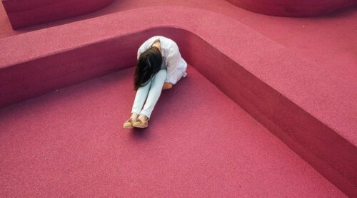 Vrouw met haar hoofd op haar knieën