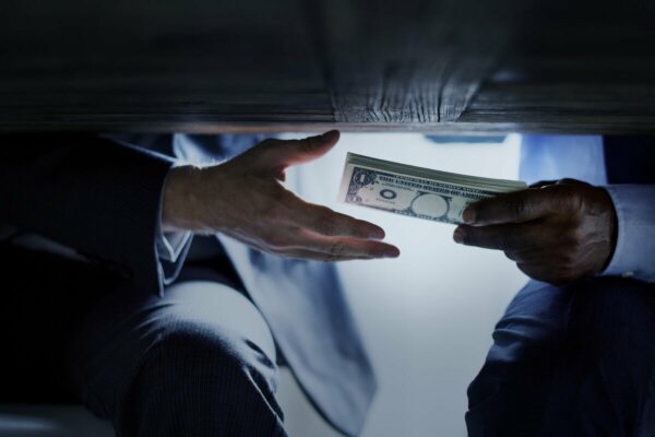 A corrupt person giving money.
