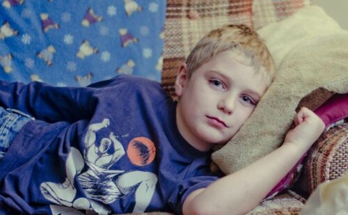 A sad boy lying on the couch.