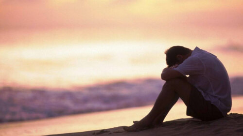 A sad man sitting by the beach thinking about extrinsic emotion regulation.