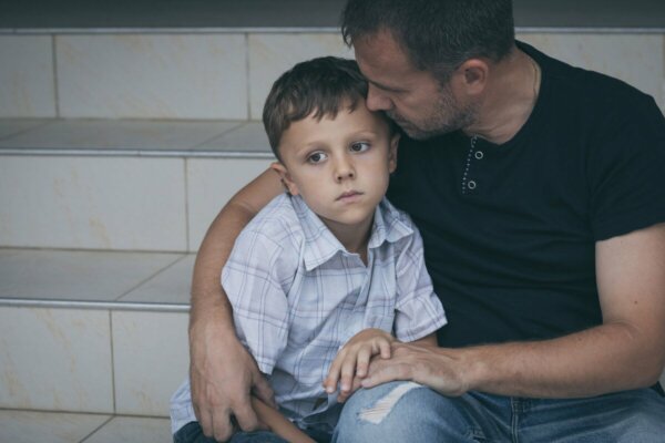 A man comforting a child.