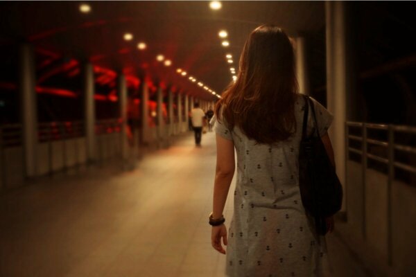 A woman crossing a bridge.