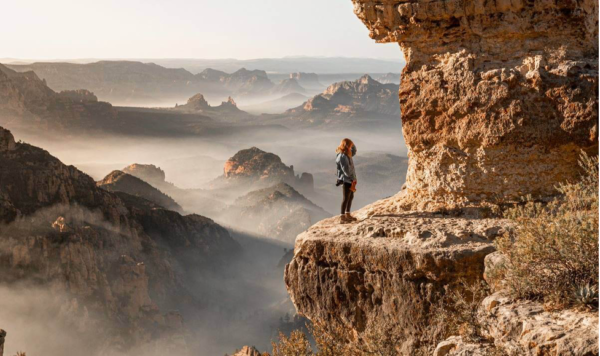 A woman standing on the edge of a cliff.