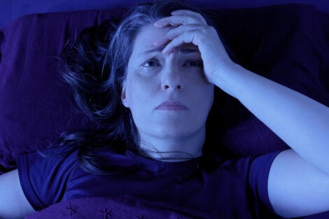 A woman in bed with a headache.
