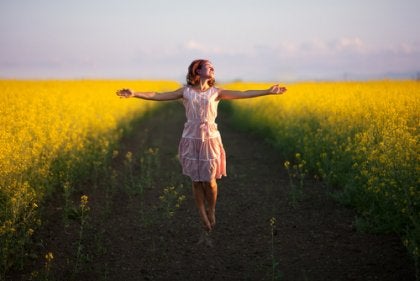 A woman walking in a country field with good self-esteem.