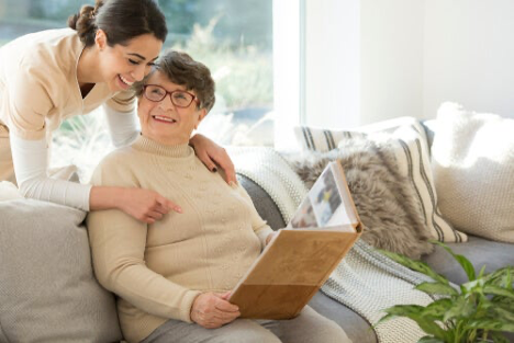 A woman reading a book talking to another.