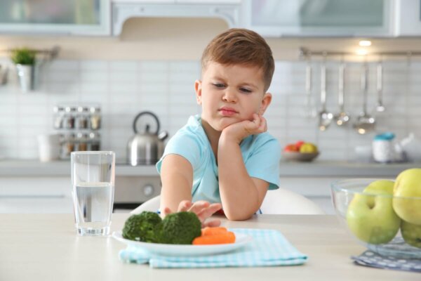 A child pushing a plate away.