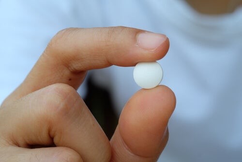 A person holding a pill.