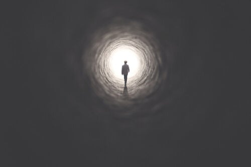 A person walking towards the light at the end of the tunnel.