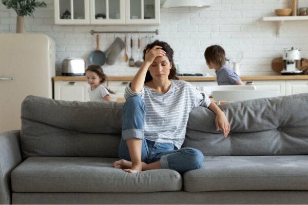 A woman overwhelmed with her children.