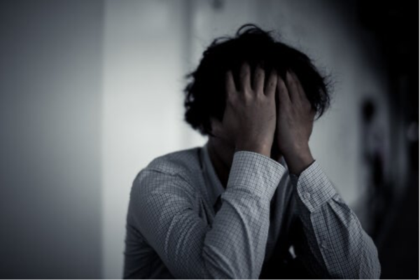 A man with his head in his hands.