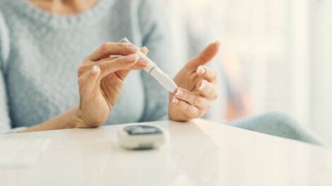 A woman doing a blood sugar finger stick.