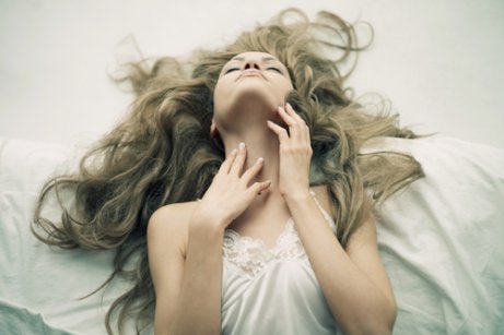 A woman on a bed with her eyes closed.