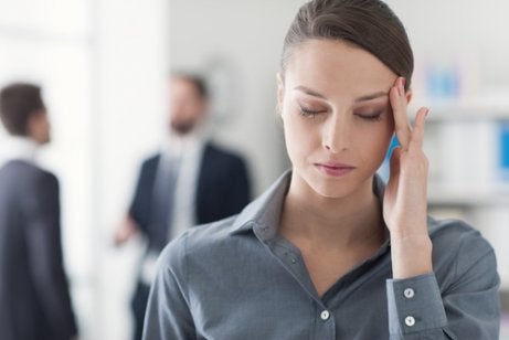 Kvinde med hovedpine på arbejdsplads