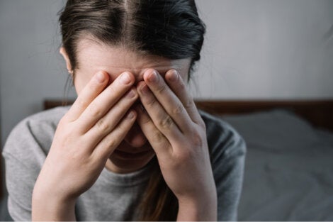 A woman with her hands on her eyes.