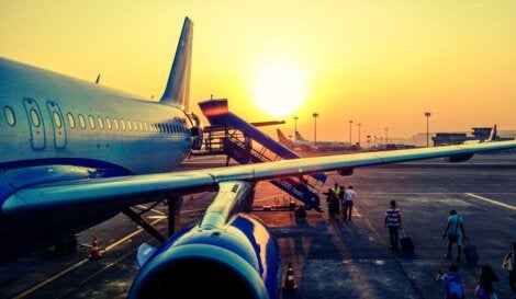People boarding a plane at sunset.