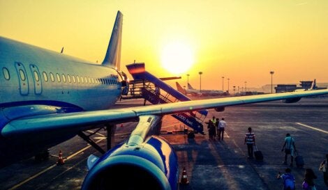 People boarding a plane at sunset.