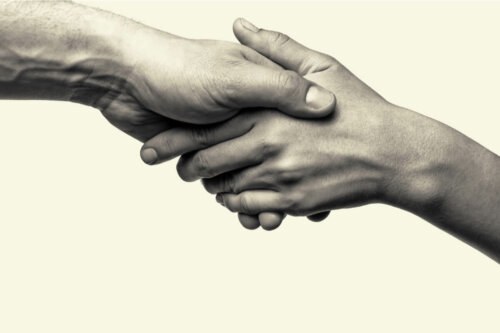Two people holding hands, representing prosocial behaviors.