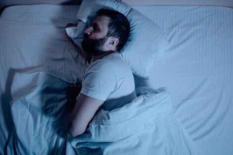 A sleeping man on his side in bed.