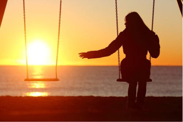 A woman sitting on a swing.