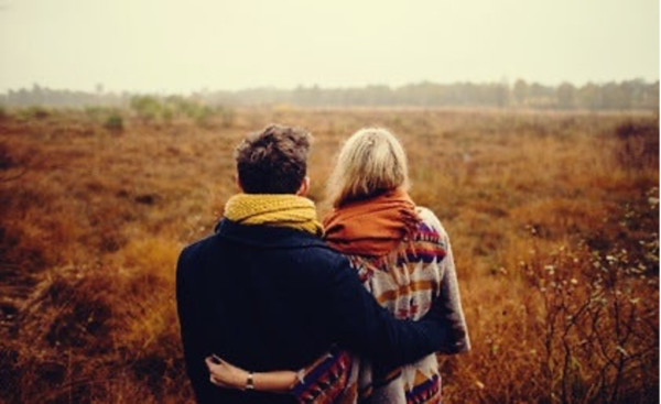 A couple with their arms around each other.