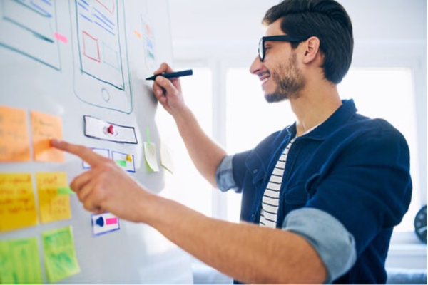 A man writing on a whiteboard.