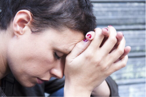 A woman with her head in her hands.