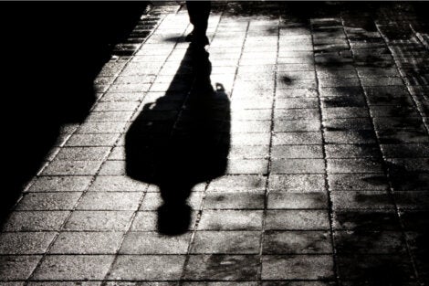 A man walking in the street at night.