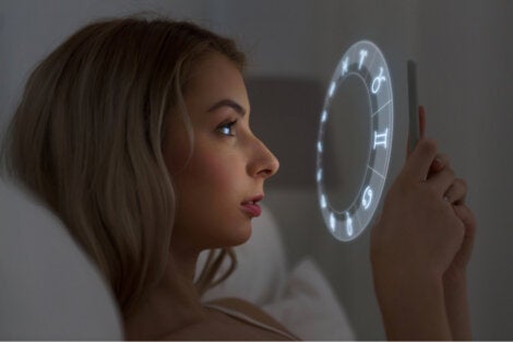 A woman reading her horoscope and experiencing illusory correlation.