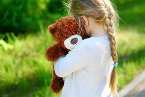 A girl hugging her teddy bear.