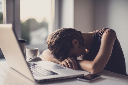 A woman sleeping at her desk.