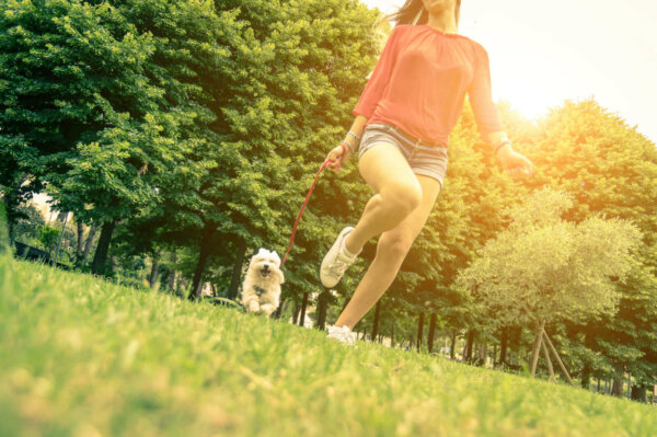 A woman walking a dog.