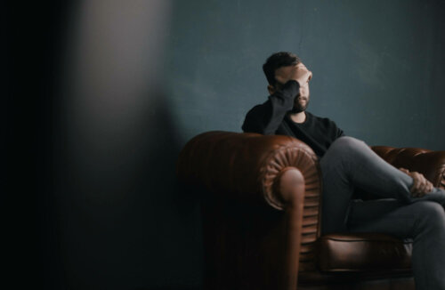 A worried man sitting on a couch.