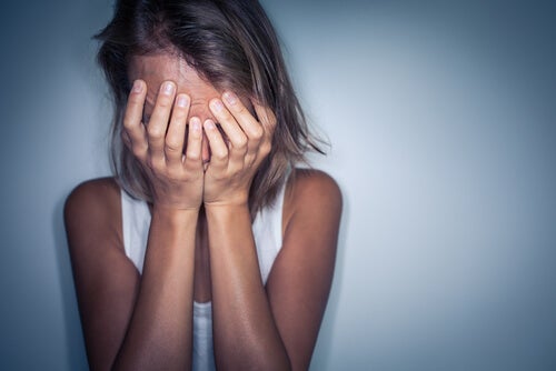 Een vrouw met de handen voor haar gezicht