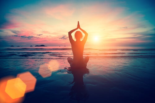 A person doing yoga at the beach.