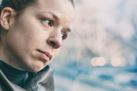A sad woman looking out the window.