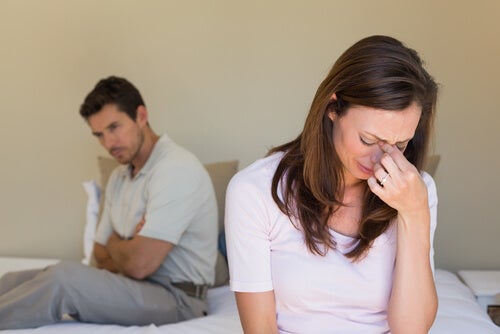 A woman crying while a man watches her.