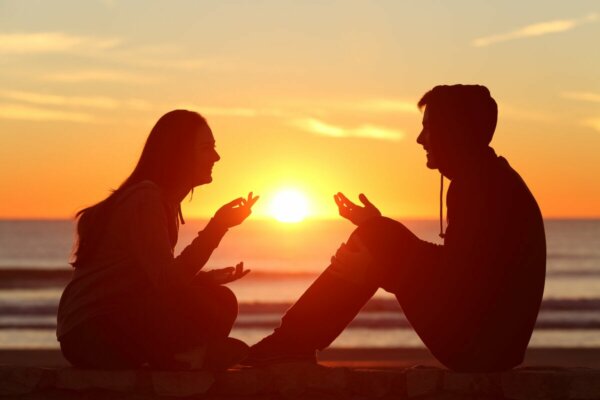 Two people talking at the beach.