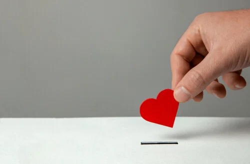 A red heart being put in a box.