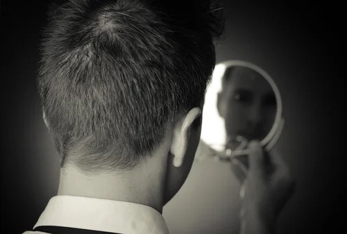 A man looking in the mirror.