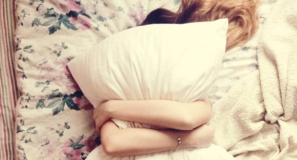 A woman hugging a pillow.
