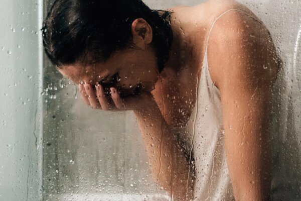 A woman crying in the shower.