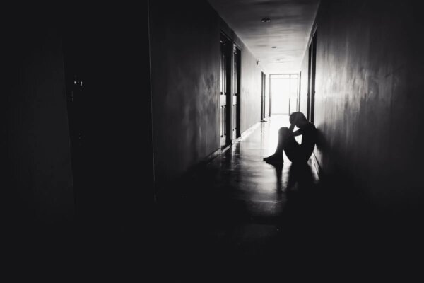 A man sitting in a corridor.