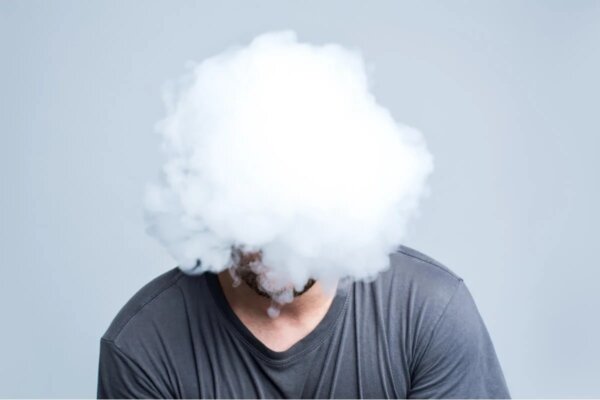 A man's head covered by a cloud.