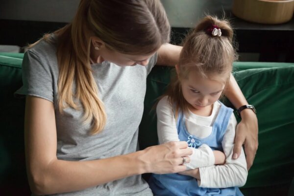 A sad child with her mother who may suffer from ASD.