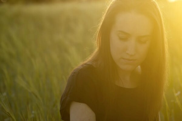 A woman looking pensive, demonstrating an explanatory style.