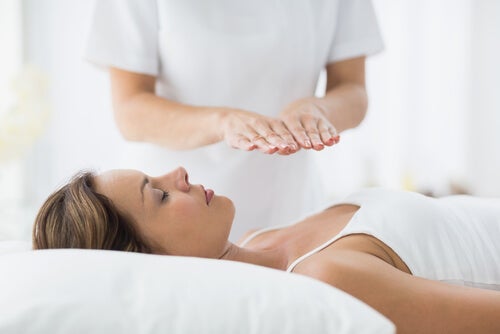 Kvinne som ligger sammen med en annen person som gir terapeutisk berøring.